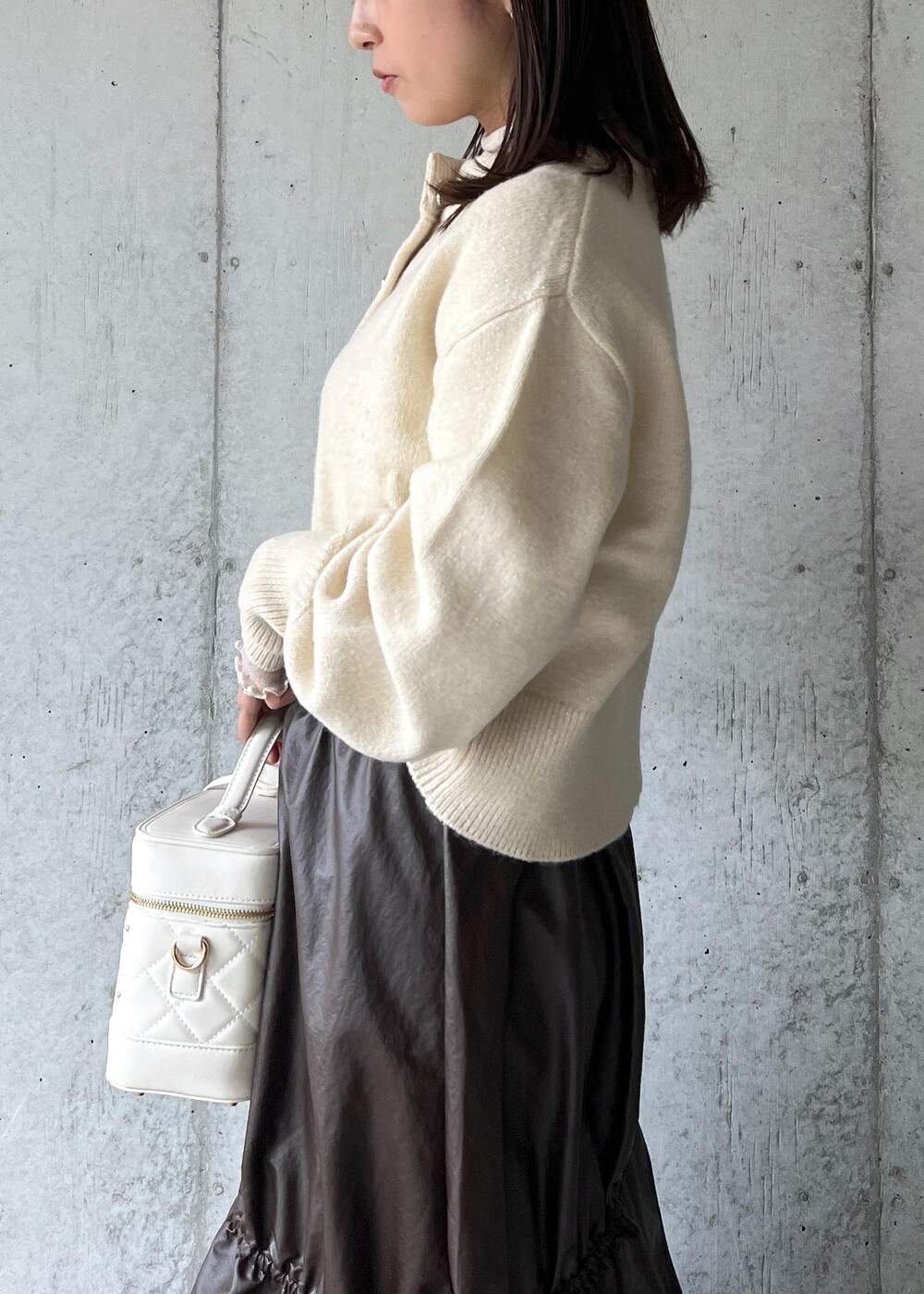 ブラウン系のスカート、ベージュ系のTシャツ/カットソー、ブラック系のパンプスを着用したレディースの冬コーディネートの8枚目の写真