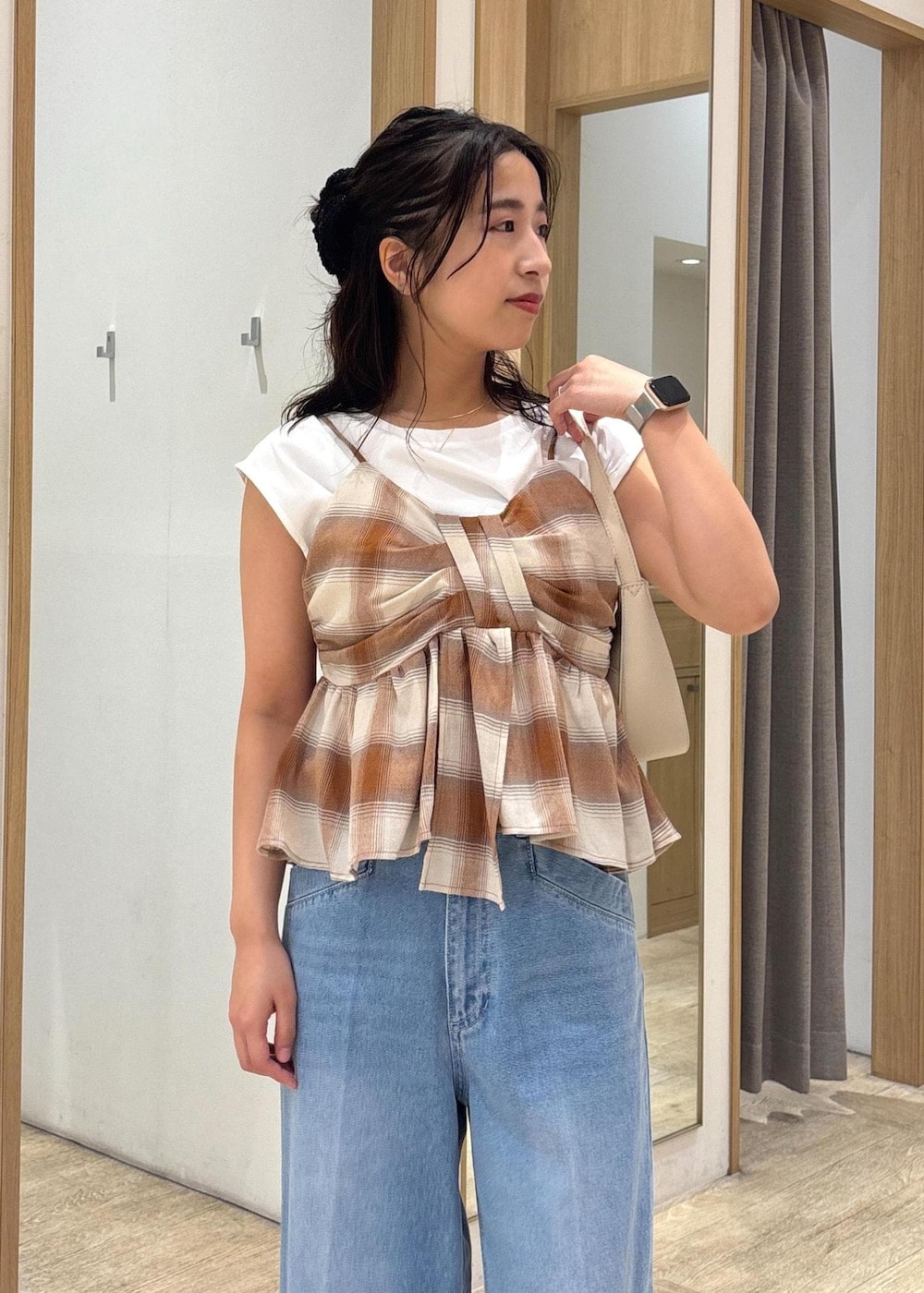 ブラック系のサンダル、ホワイト系のショルダーバッグ、ブルー系のデニムパンツを着用したレディースの夏コーディネートの4枚目の写真