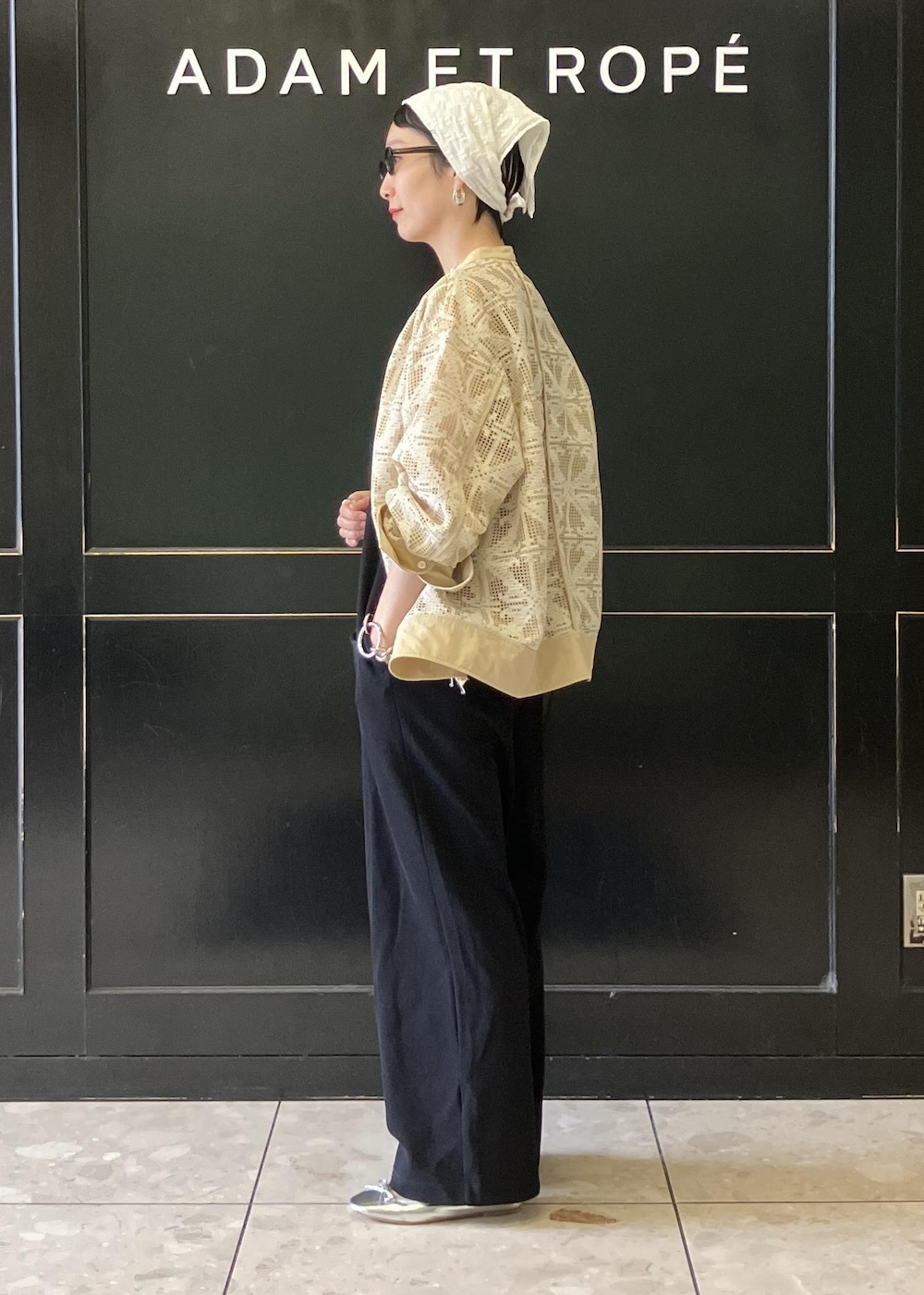 ベージュ系のシャツ/ブラウス、ブラック系のつなぎ/オールインワン、シルバー系のバレエシューズを着用したレディースの春コーディネートの2枚目の写真