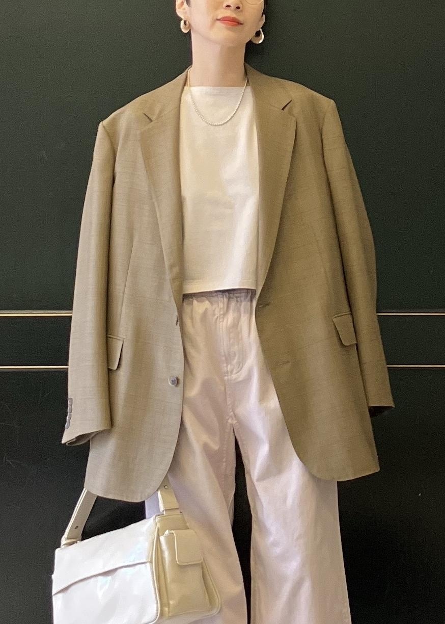 ベージュ系のショルダーバッグ、ホワイト系のパンプス、ピンク系のチノパンツを着用したレディースの冬コーディネートの5枚目の写真