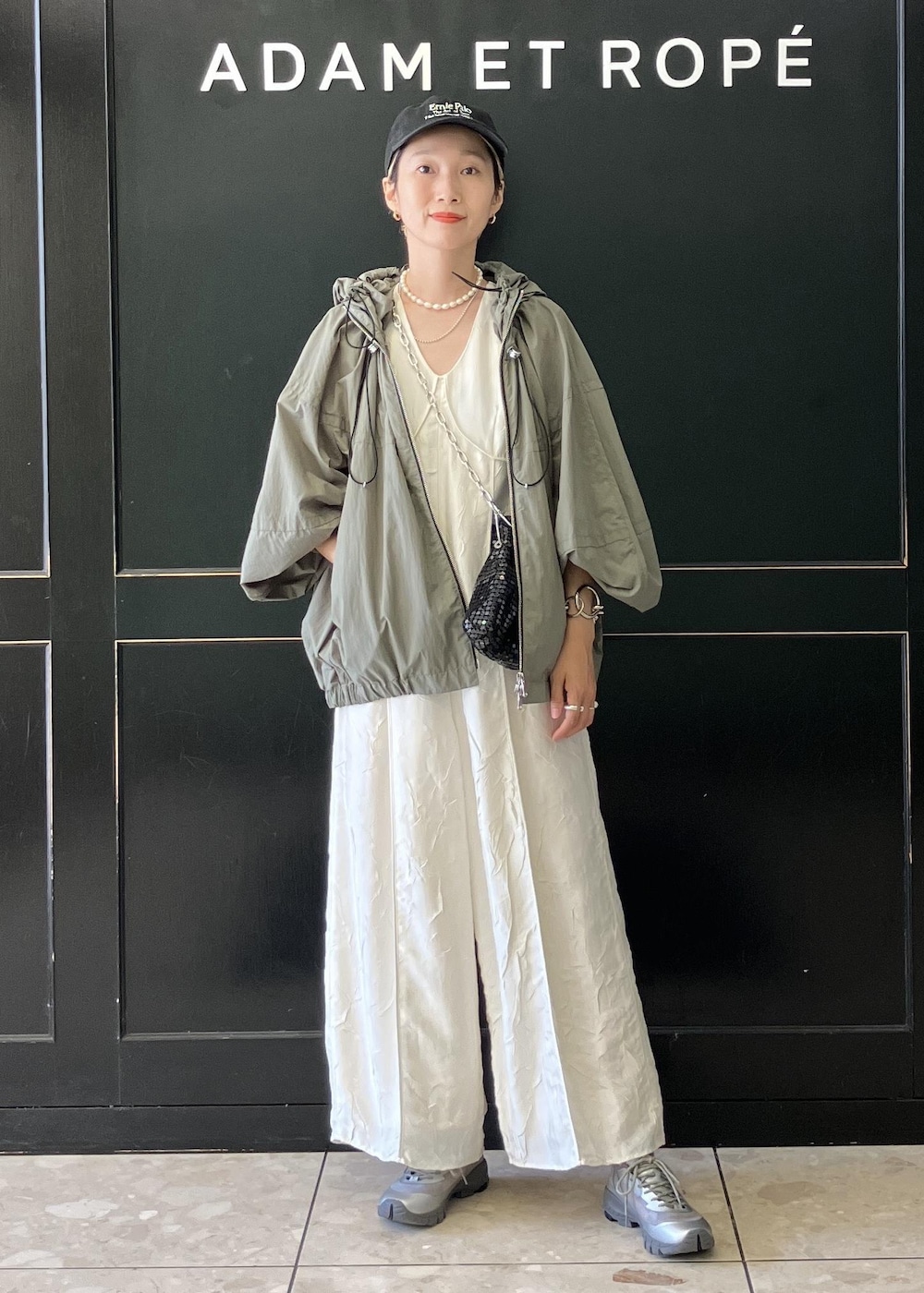 ブラック系のハンドバッグ、グリーン系のその他アウター、ホワイト系のつなぎ/オールインワンを着用したレディースの夏コーディネートの3枚目の写真