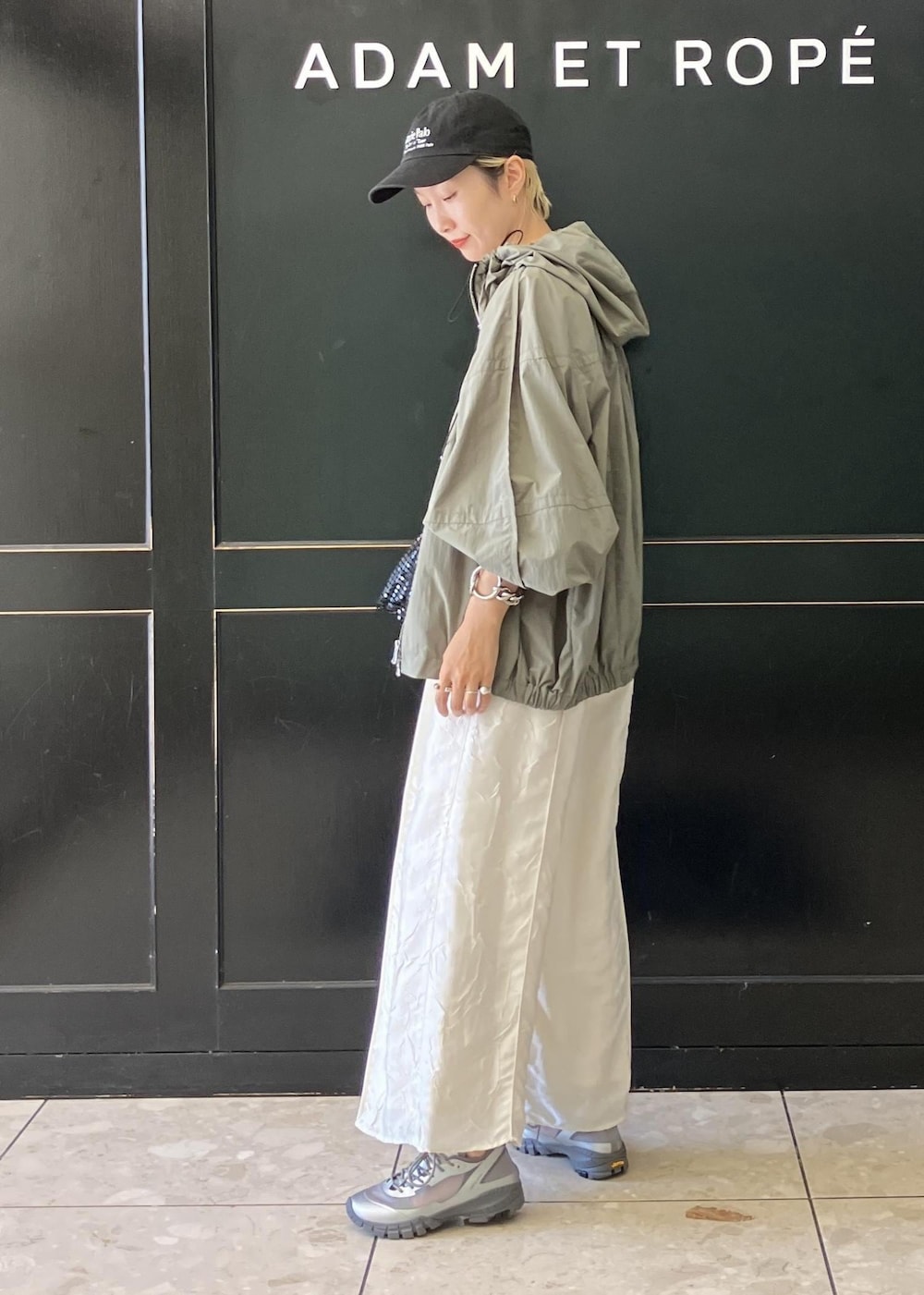 ブラック系のハンドバッグ、グリーン系のその他アウター、ホワイト系のつなぎ/オールインワンを着用したレディースの夏コーディネートの2枚目の写真