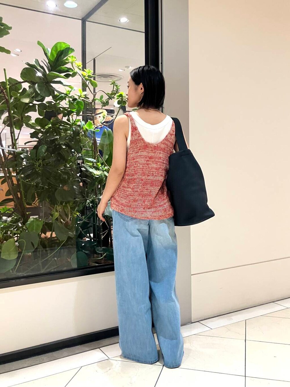 ホワイト系のタンクトップ、レッド系のニット/セーター、ブルー系のデニムパンツを着用したレディースの夏コーディネートの4枚目の写真