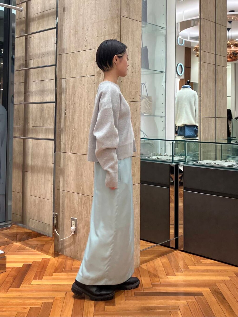 グレー系のニット/セーター、グリーン系のスカートを着用したレディースの冬コーディネートの2枚目の写真