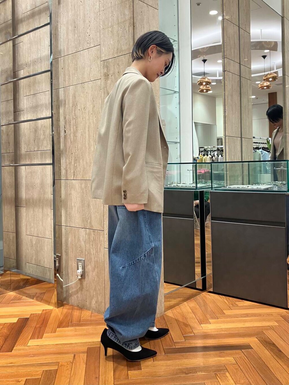 ブラック系のパンプス、ピンク系のニット/セーター、ブルー系のデニムパンツを着用したレディースの冬コーディネートの2枚目の写真