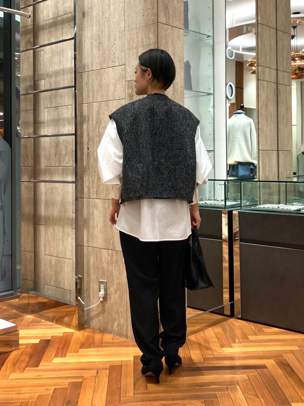 ホワイト系のシャツ/ブラウス、ブラック系のパンプス、ブラック系のベストを着用したレディースの冬コーディネートの3枚目の写真