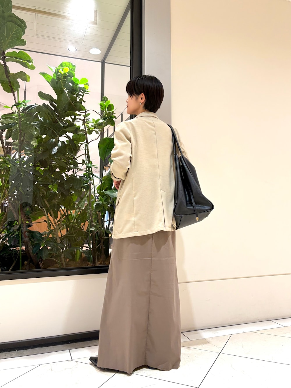 グレー系のスカート、ブルー系のTシャツ/カットソー、ベージュ系のその他アウターを着用したレディースの春コーディネートの3枚目の写真