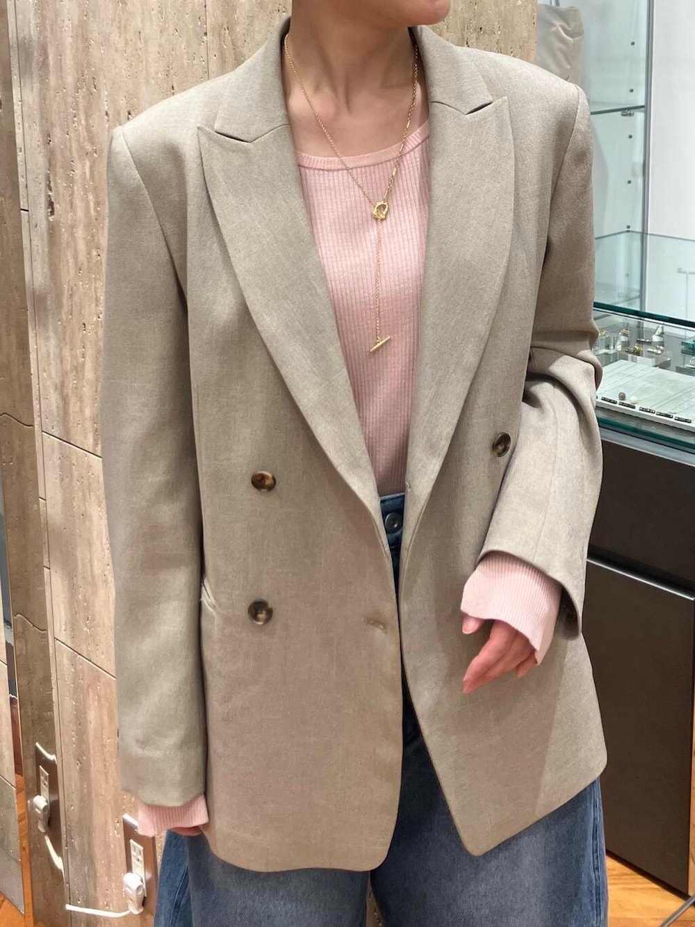 ブラック系のパンプス、ピンク系のニット/セーター、ブルー系のデニムパンツを着用したレディースの冬コーディネートの3枚目の写真