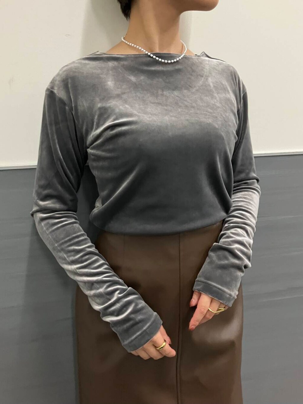 ブラウン系のスカート、グレー系のTシャツ/カットソー、ブラック系のブーツを着用したレディースの秋コーディネートの3枚目の写真