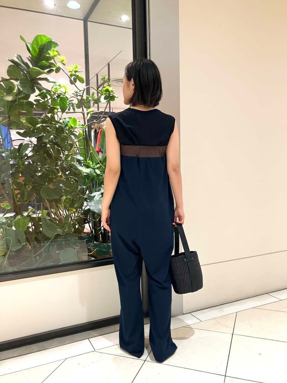 ブルー系のサロペット/オーバーオール、ブラック系のタンクトップ、ブラック系のかごバッグを着用したレディースの夏コーディネートの3枚目の写真