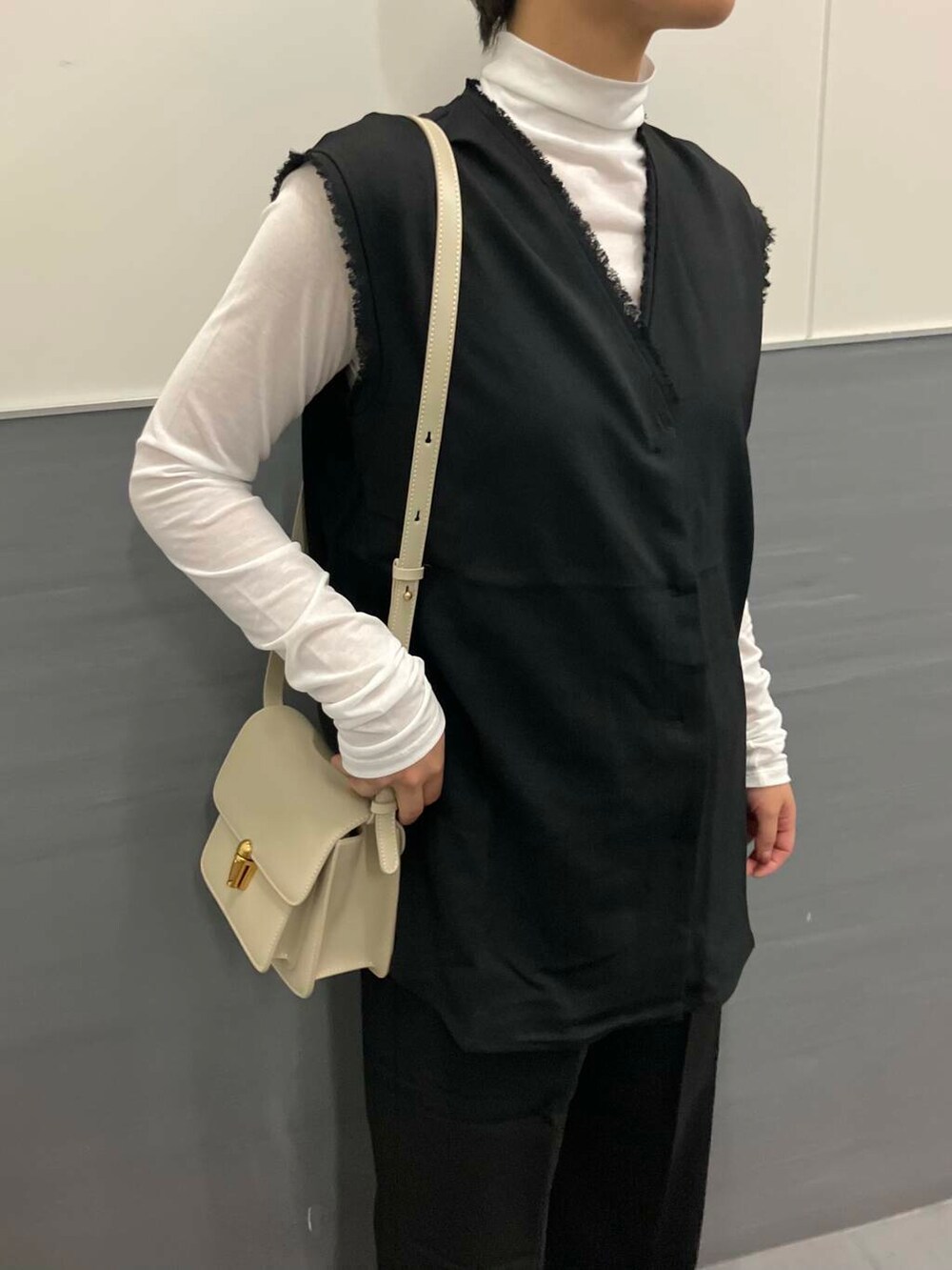 ブラック系のセットアップ、ホワイト系のTシャツ/カットソー、ベージュ系のショルダーバッグを着用したレディースの秋コーディネートの2枚目の写真