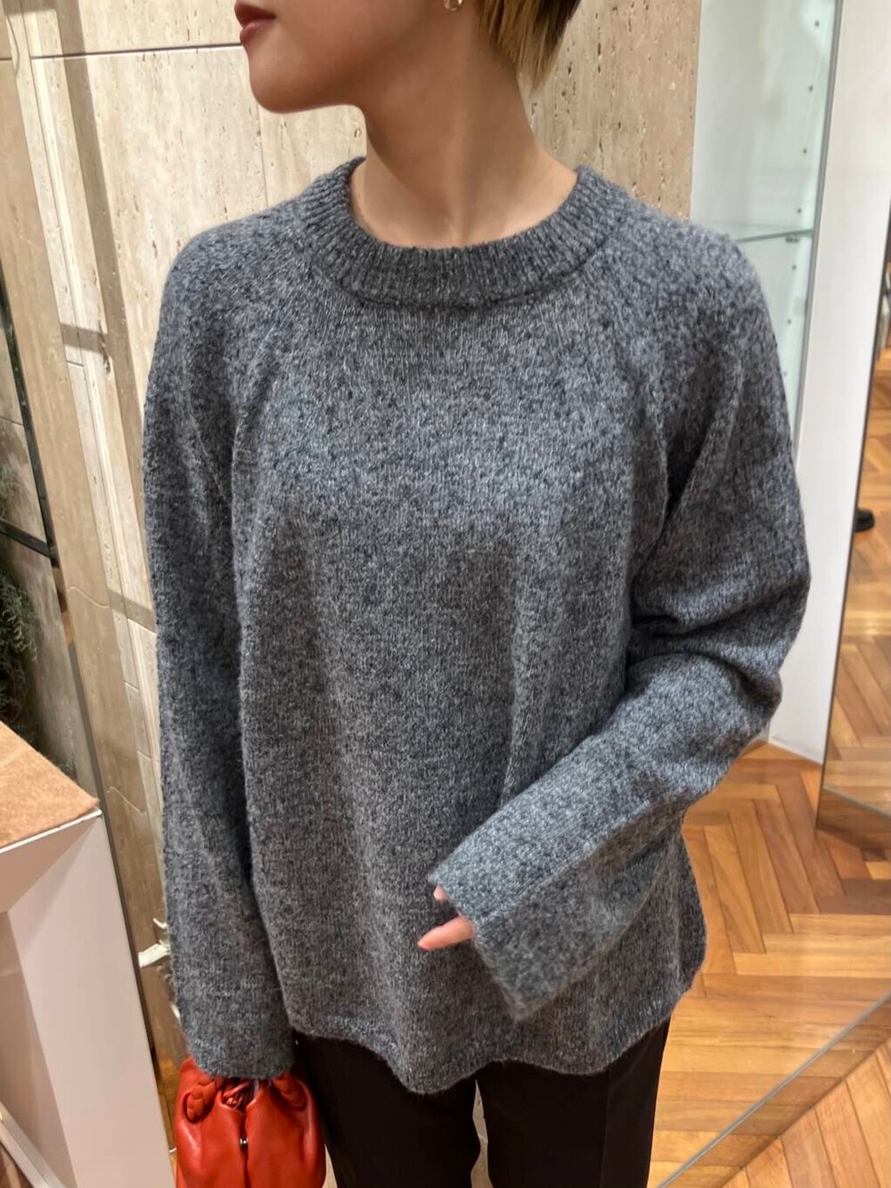 ブラック系のその他パンツ、グレー系のニット/セーター、レッド系のショルダーバッグを着用したレディースの冬コーディネートの3枚目の写真