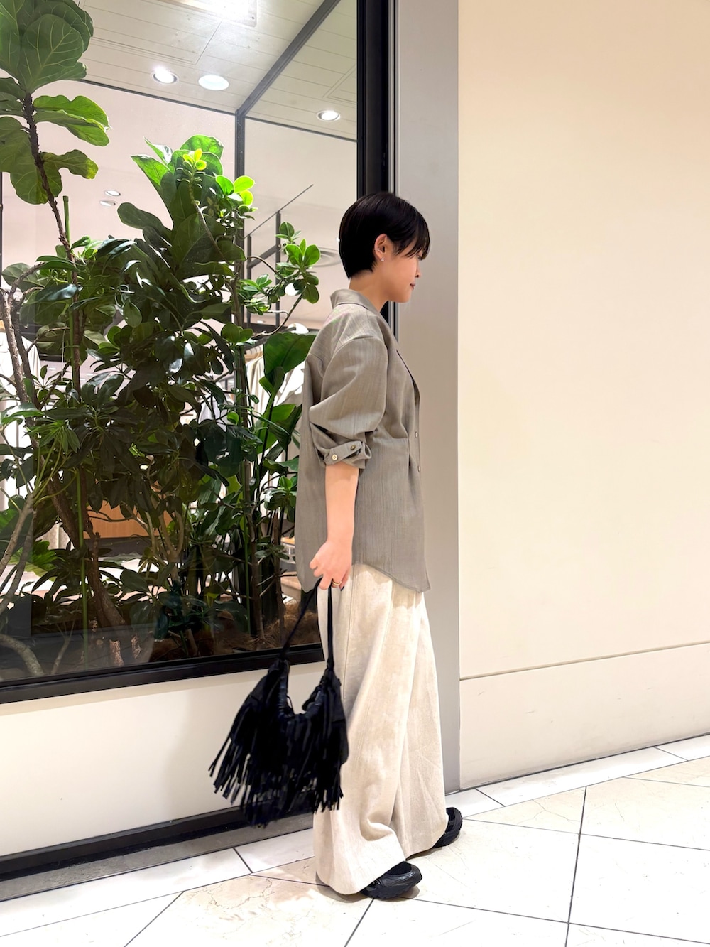 ベージュ系のシャツ/ブラウス、オレンジ系のタンクトップ、ホワイト系のその他パンツを着用したレディースの春コーディネートの3枚目の写真