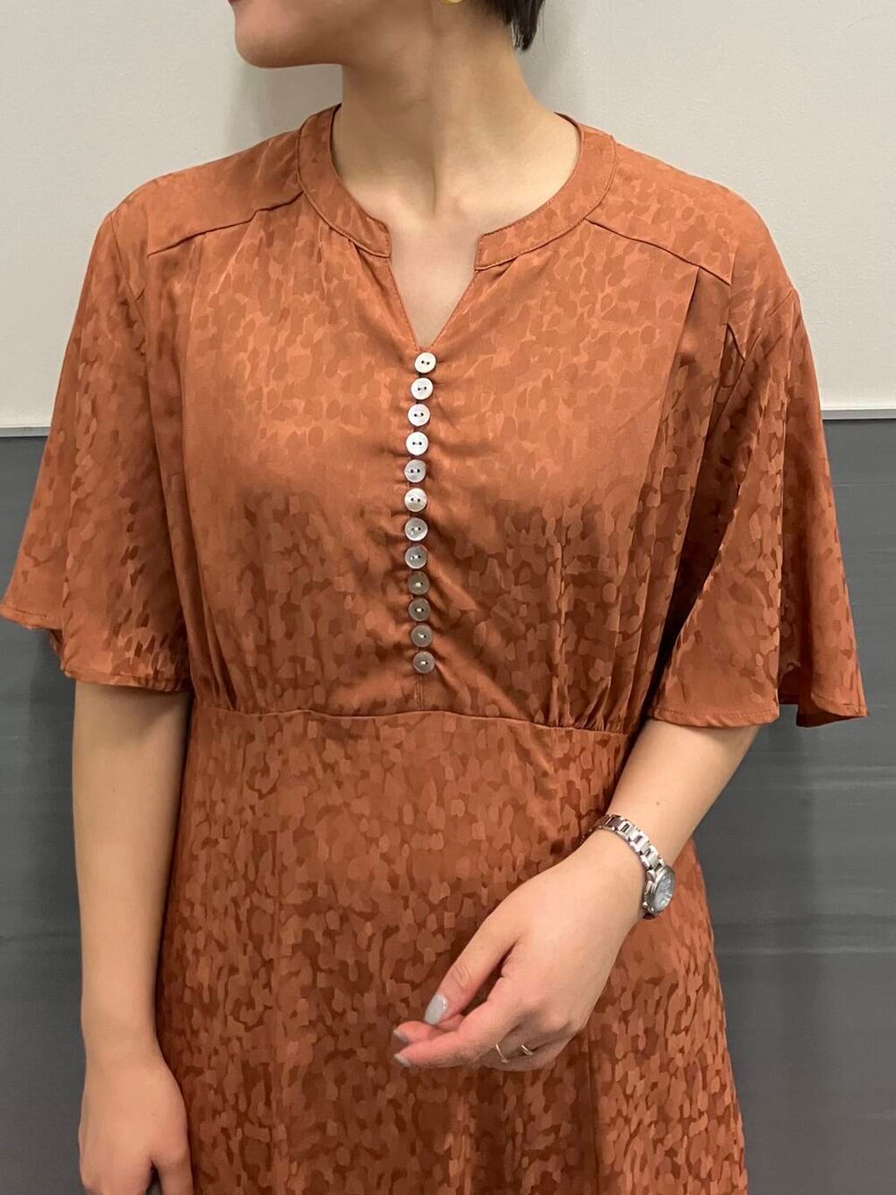 オレンジ系のワンピース、ホワイト系のトートバッグ、ホワイト系のその他シューズを着用したレディースの夏コーディネートの2枚目の写真