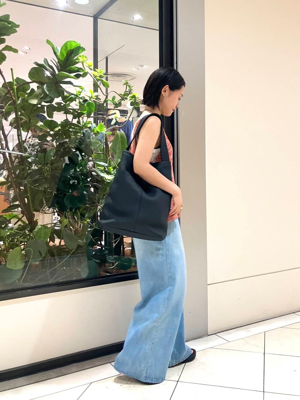 ホワイト系のタンクトップ、レッド系のニット/セーター、ブルー系のデニムパンツを着用したレディースの夏コーディネートの3枚目の写真