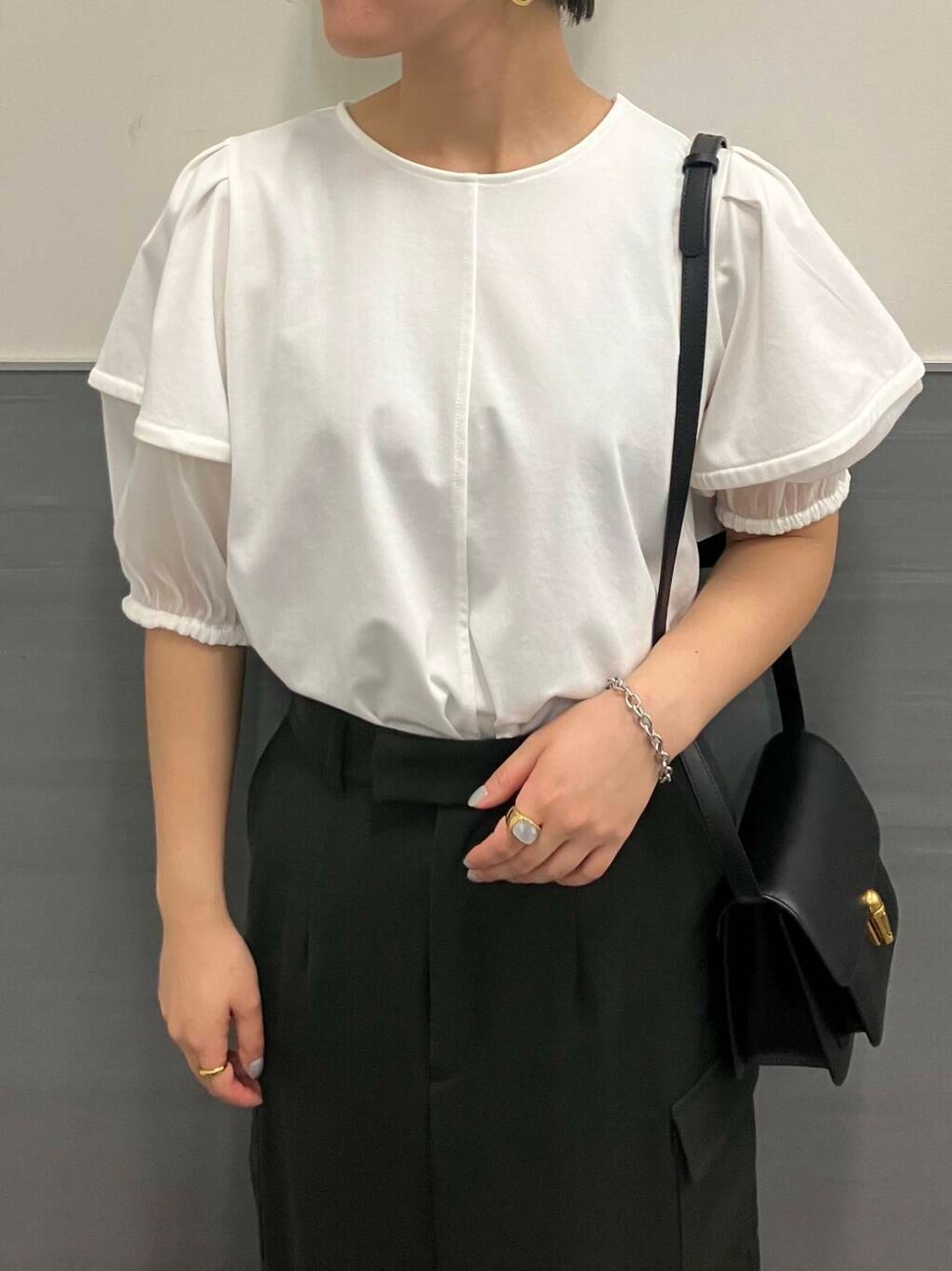 ホワイト系のシャツ/ブラウス、グリーン系のスカート、ブラック系のショルダーバッグを着用したレディースの夏コーディネートの3枚目の写真