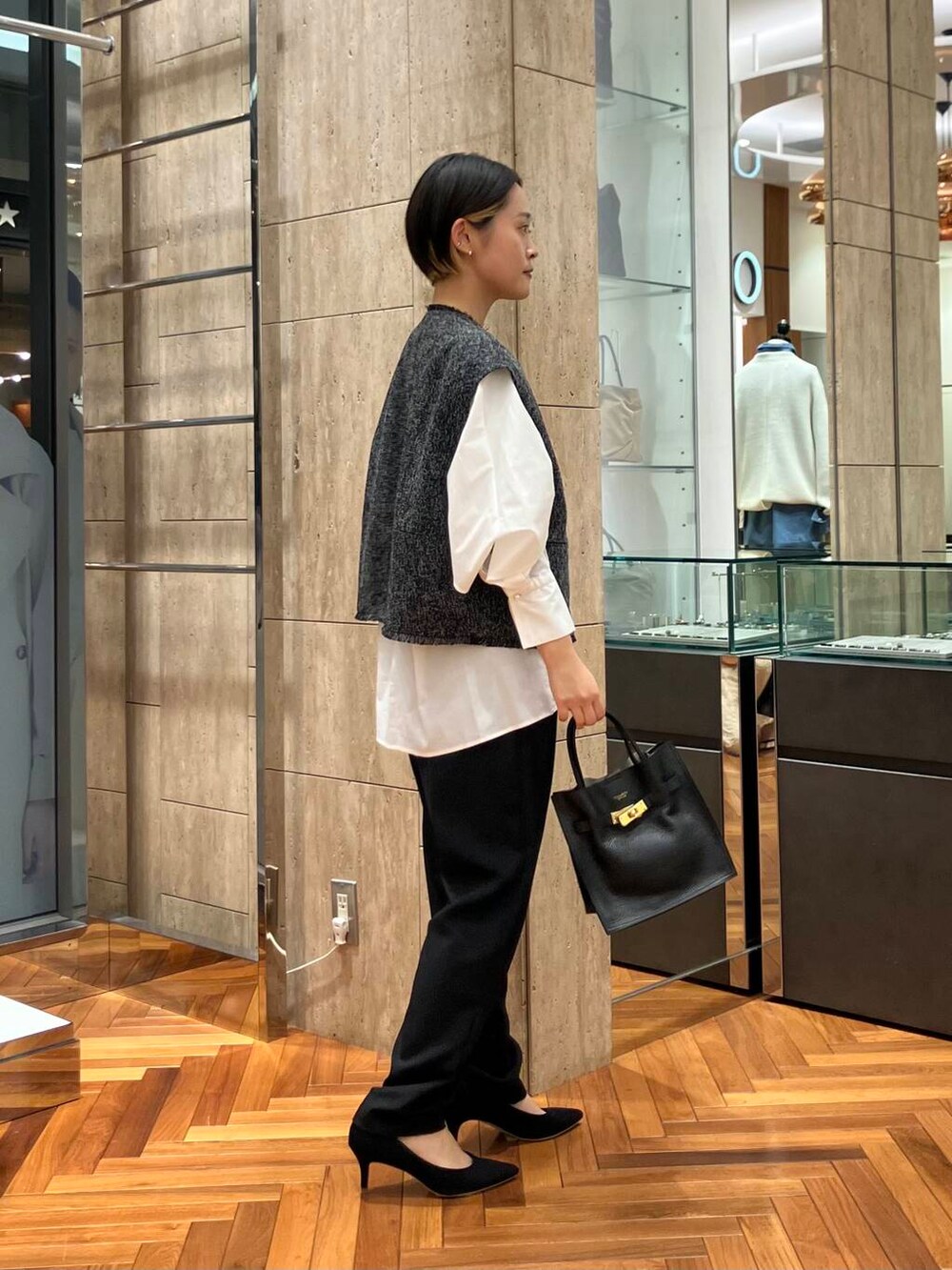 ホワイト系のシャツ/ブラウス、ブラック系のパンプス、ブラック系のベストを着用したレディースの冬コーディネートの2枚目の写真