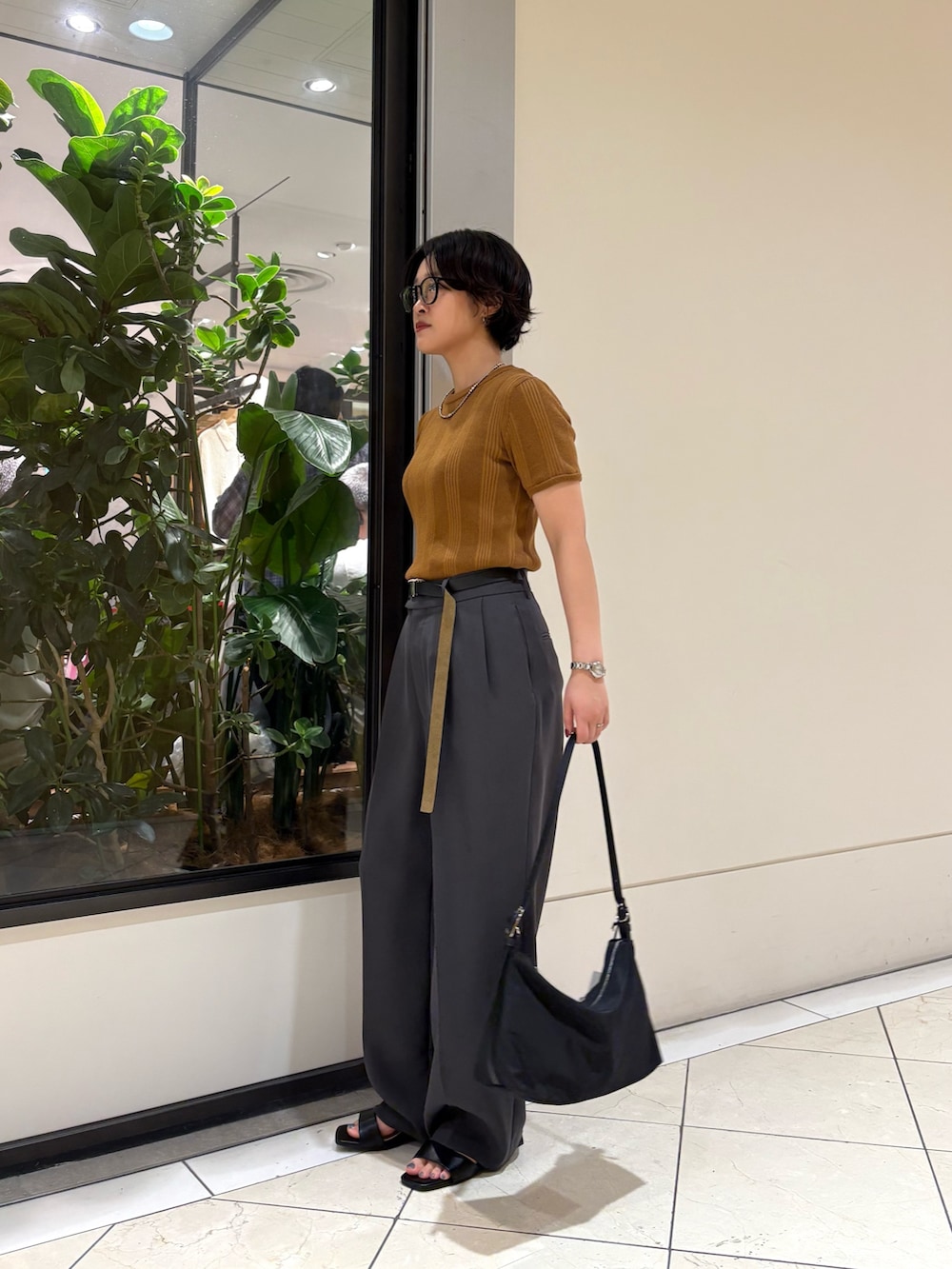 ブラック系のショルダーバッグ、グレー系のその他パンツ、イエロー系のニット/セーターを着用したレディースの夏コーディネートの2枚目の写真
