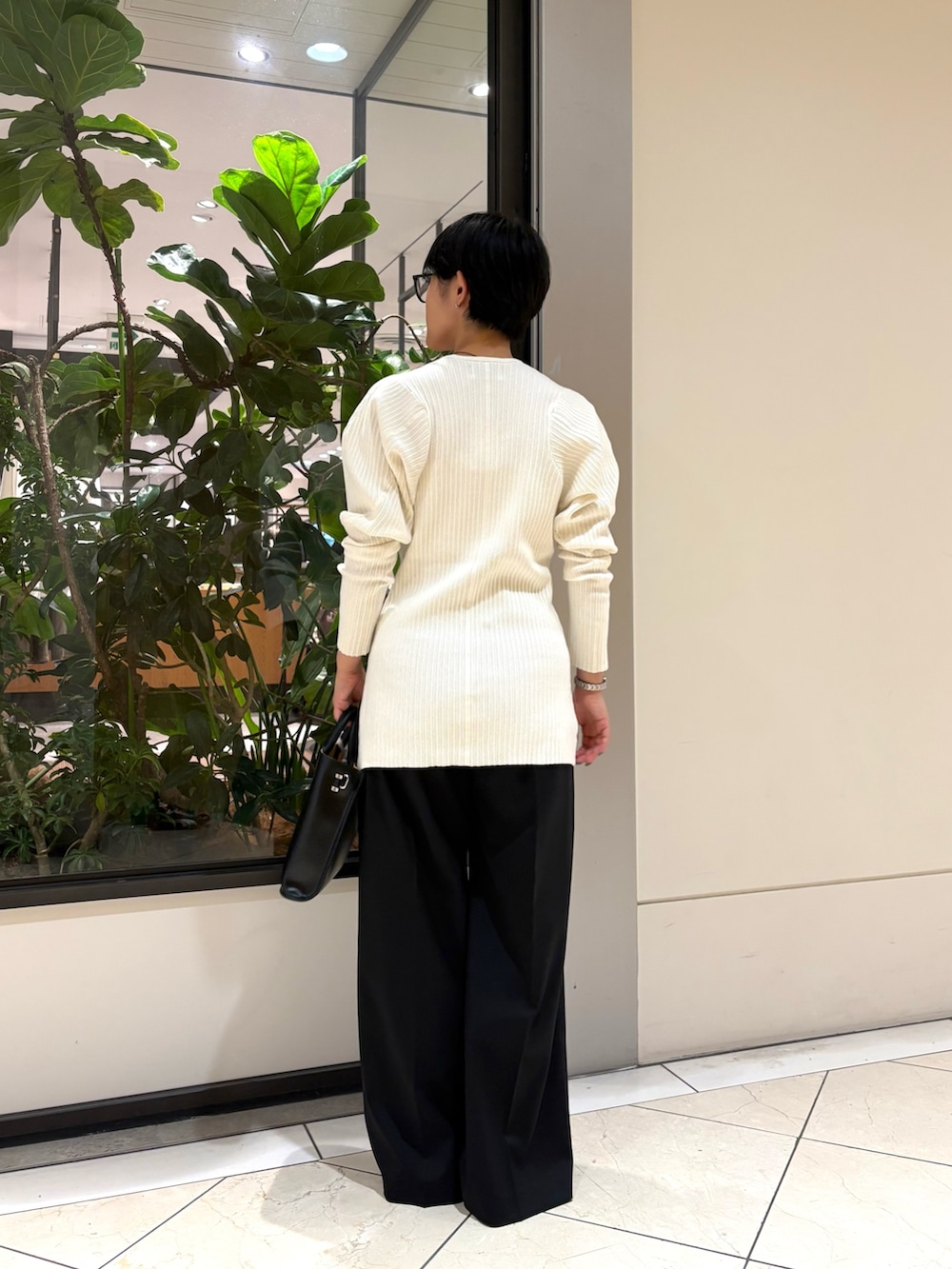 ホワイト系のニット/セーター、ブラック系のその他パンツ、ブラック系のショルダーバッグを着用したレディースの秋コーディネートの3枚目の写真