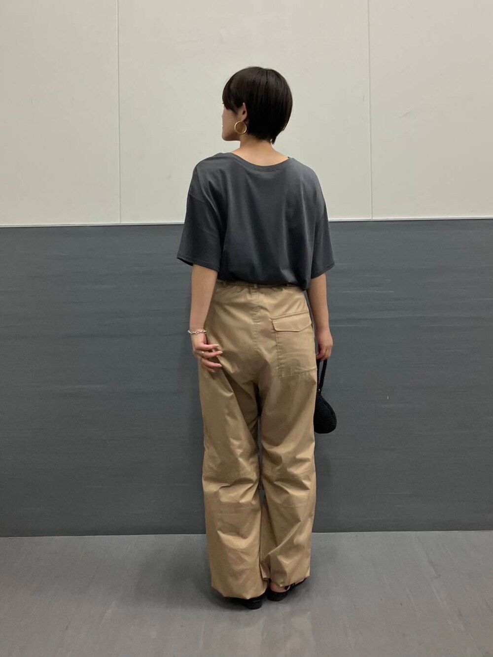 グレー系のTシャツ/カットソー、ベージュ系のその他パンツ、ブラック系のハンドバッグを着用したレディースの夏コーディネートの2枚目の写真