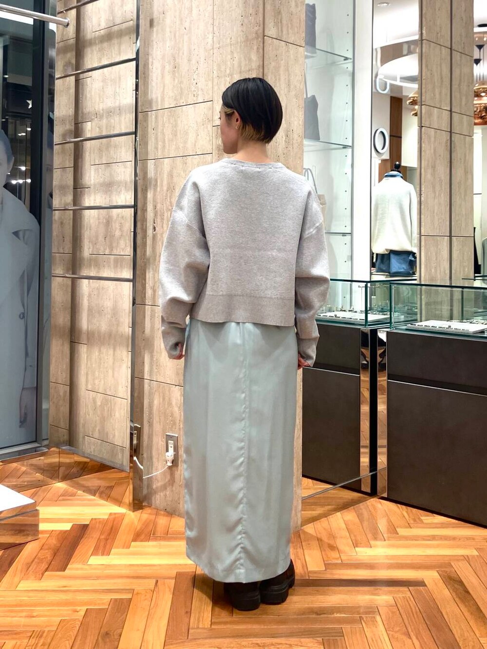 グレー系のニット/セーター、グリーン系のスカートを着用したレディースの冬コーディネートの3枚目の写真