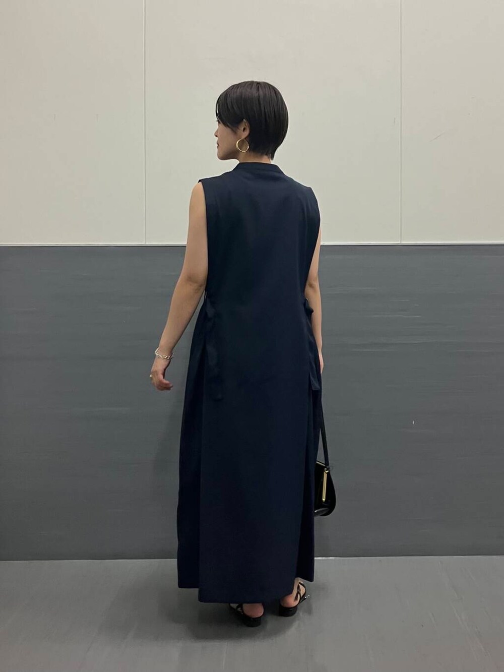 ブルー系のワンピース、ブラック系のハンドバッグを着用したレディースの夏コーディネートの2枚目の写真