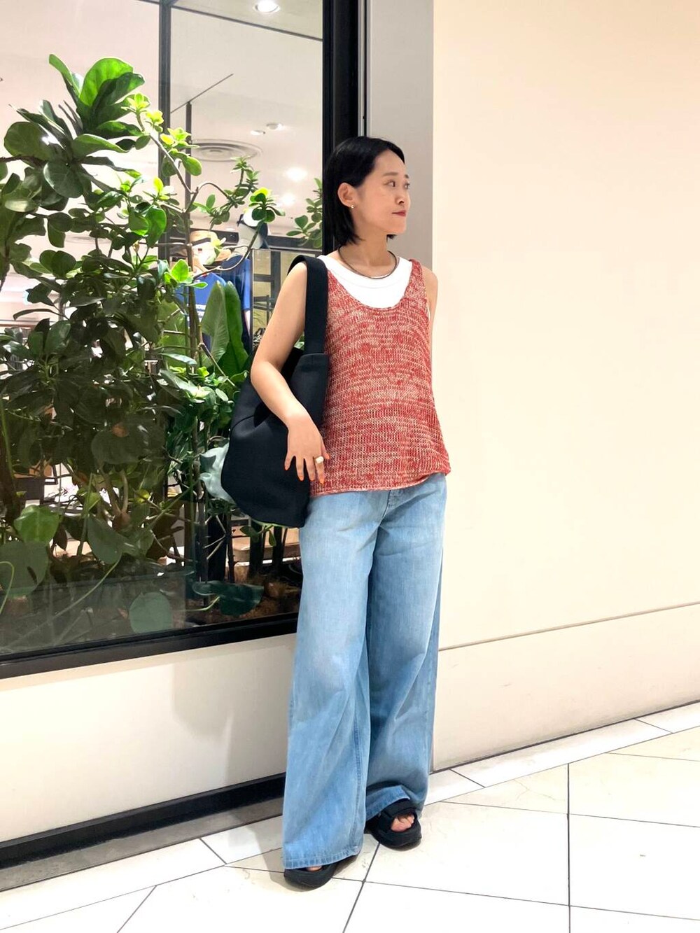 ホワイト系のタンクトップ、レッド系のニット/セーター、ブルー系のデニムパンツを着用したレディースの夏コーディネートの2枚目の写真