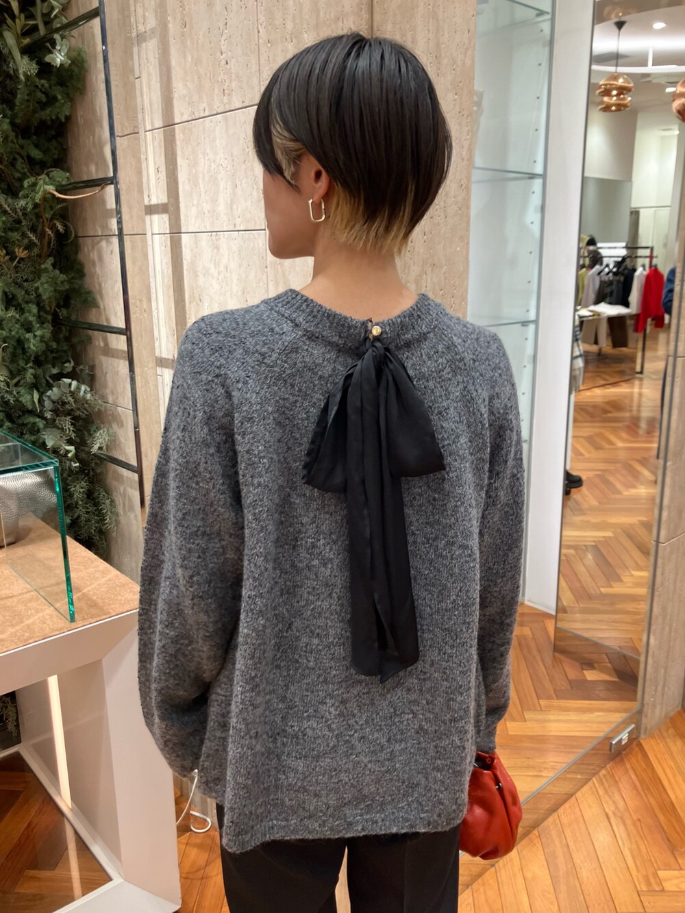 グレー系のニット/セーター、ブラック系のその他パンツを着用したレディースの冬コーディネートの2枚目の写真