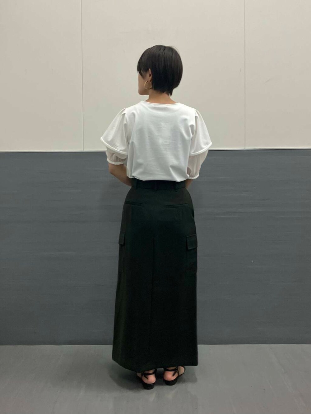 ホワイト系のシャツ/ブラウス、グリーン系のスカート、ブラック系のショルダーバッグを着用したレディースの夏コーディネートの2枚目の写真