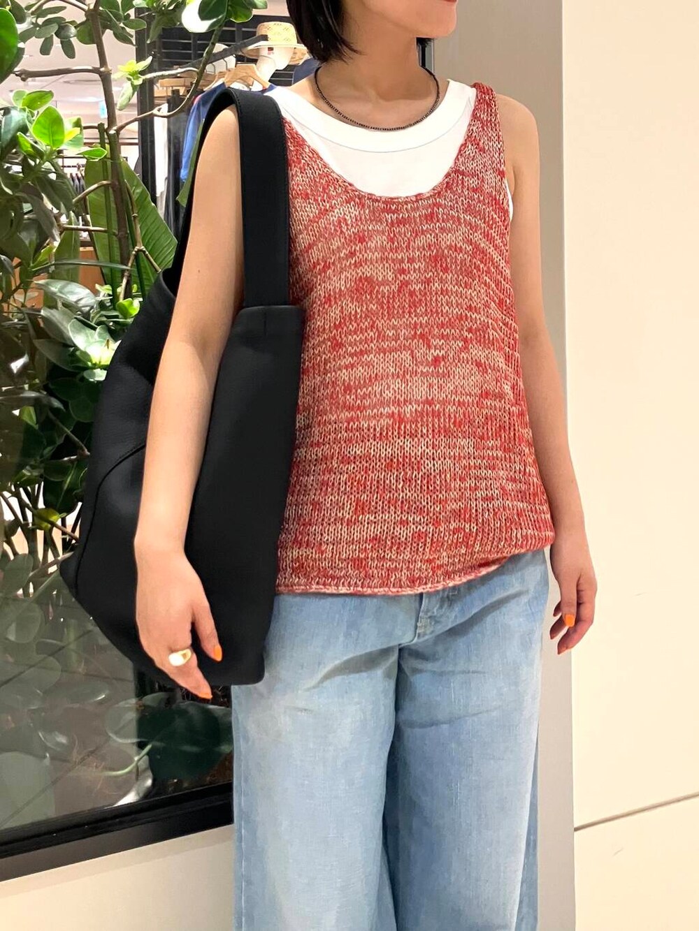 ホワイト系のタンクトップ、レッド系のニット/セーター、ブルー系のデニムパンツを着用したレディースの夏コーディネートの5枚目の写真