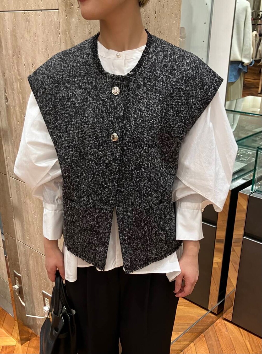 ホワイト系のシャツ/ブラウス、ブラック系のパンプス、ブラック系のベストを着用したレディースの冬コーディネートの4枚目の写真