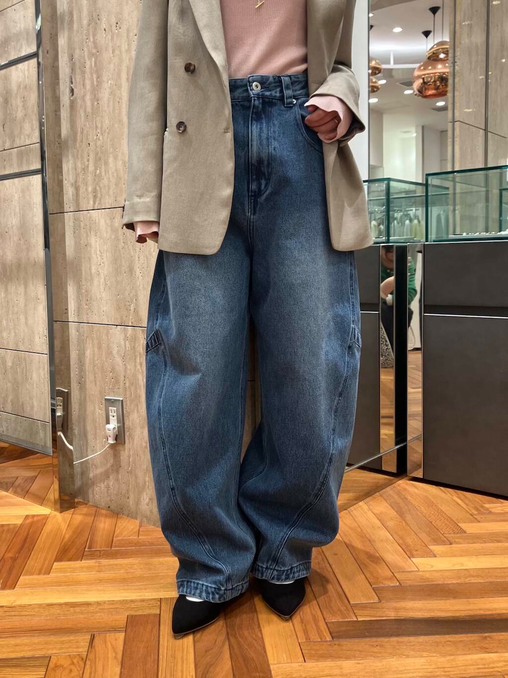 ブラック系のパンプス、ピンク系のニット/セーター、ブルー系のデニムパンツを着用したレディースの冬コーディネートの4枚目の写真