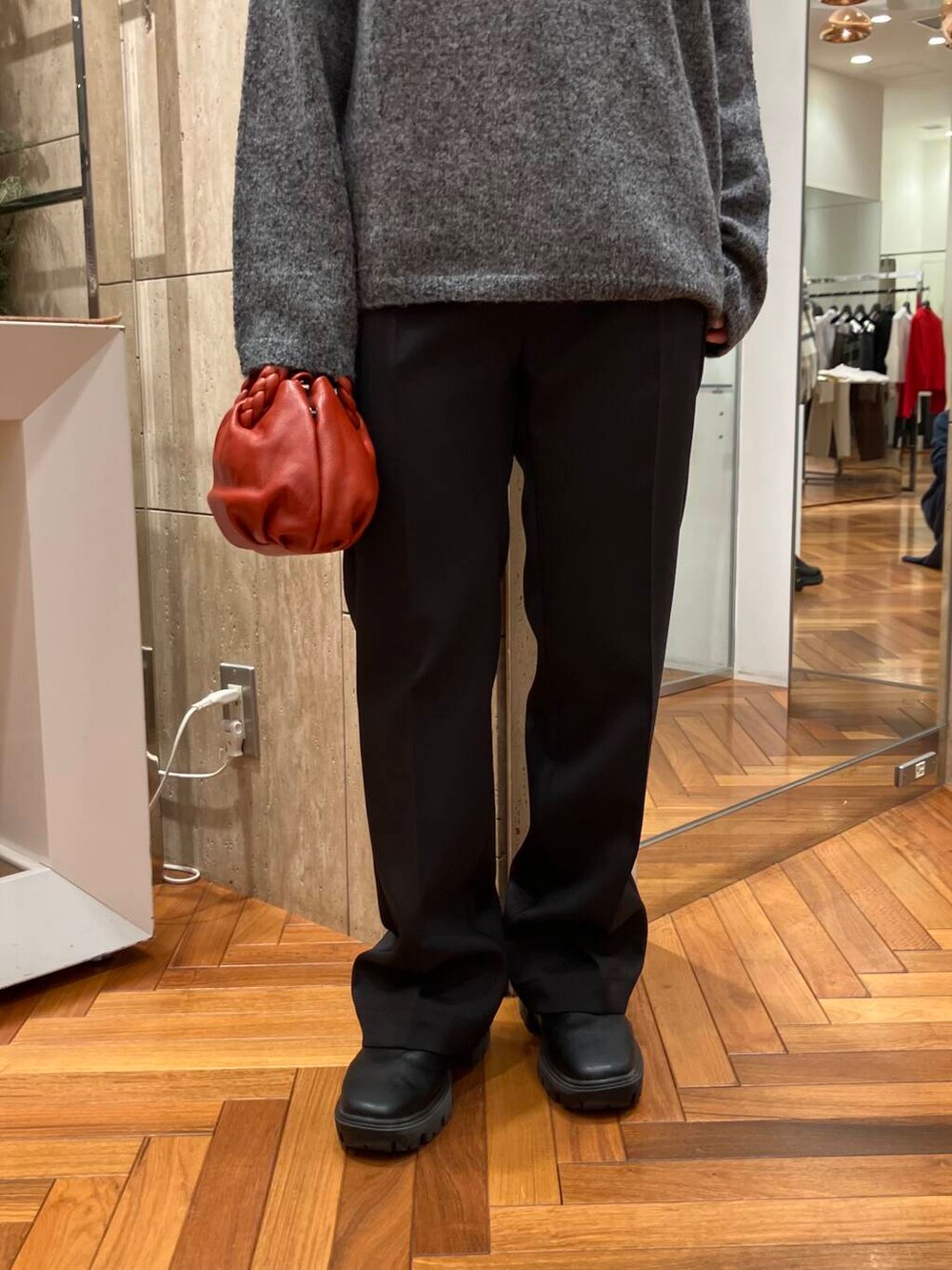ブラック系のその他パンツ、グレー系のニット/セーター、レッド系のショルダーバッグを着用したレディースの冬コーディネートの4枚目の写真