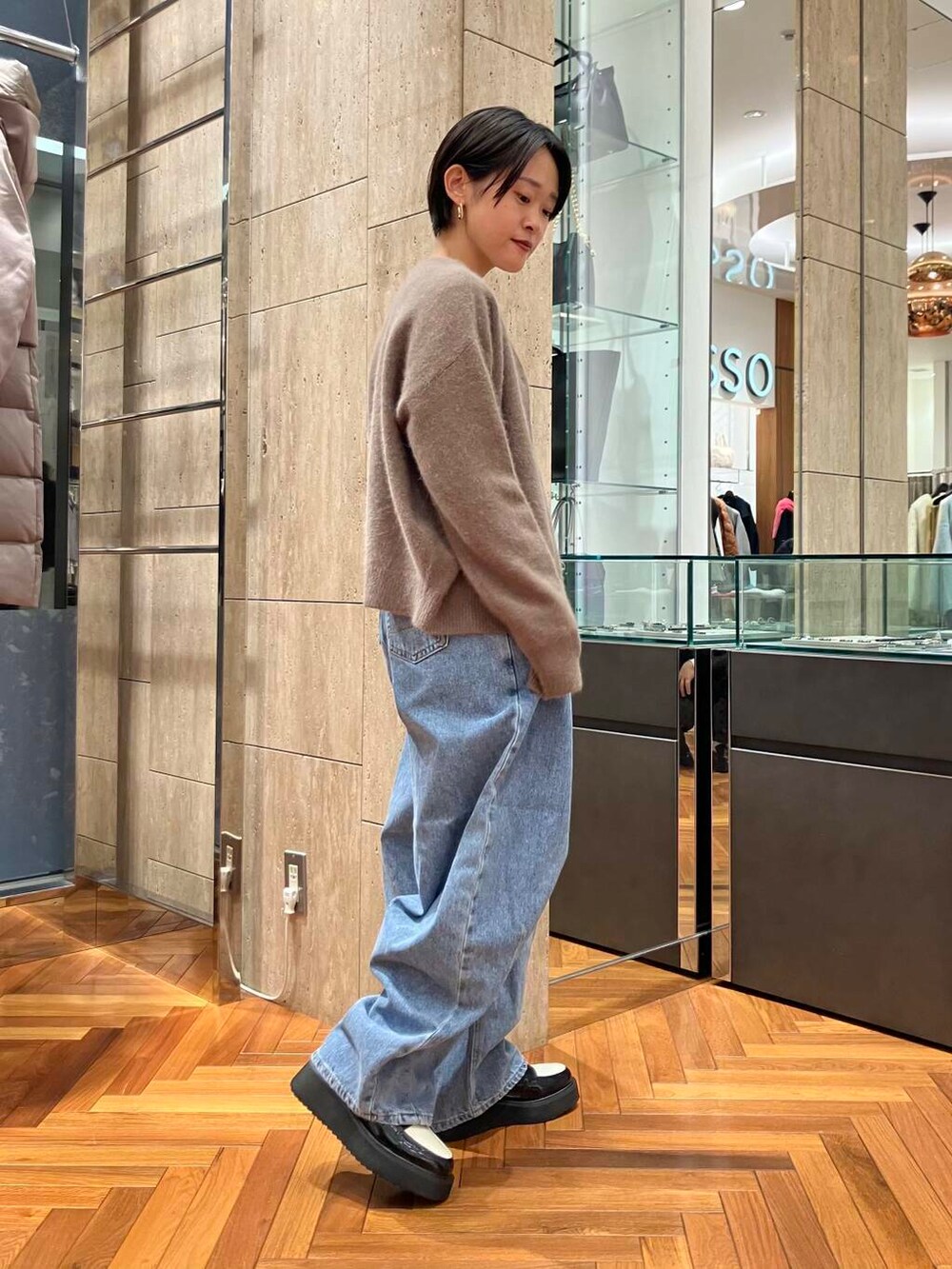 ブルー系のデニムパンツ、ホワイト系のTシャツ/カットソー、イエロー系のカーディガン/ボレロを着用したレディースの秋コーディネートの2枚目の写真