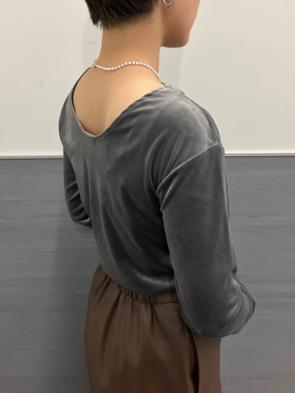 ブラウン系のスカート、グレー系のTシャツ/カットソー、ブラック系のブーツを着用したレディースの秋コーディネートの4枚目の写真