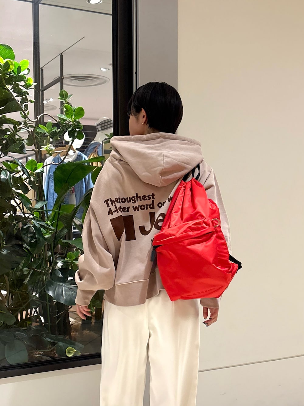 ベージュ系のパーカー、ホワイト系のその他パンツ、レッド系のバックパック/リュックを着用したレディースの冬コーディネートの4枚目の写真