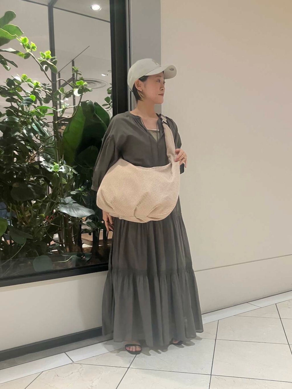 グリーン系のワンピース、ブラウン系のトートバッグ、グリーン系のタンクトップを着用したレディースの春コーディネートの2枚目の写真