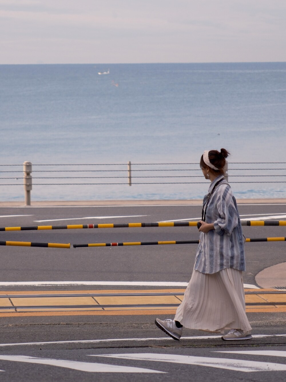 ベージュ系のスニーカー、ベージュ系のスカートを着用したレディースの秋コーディネートの2枚目の写真