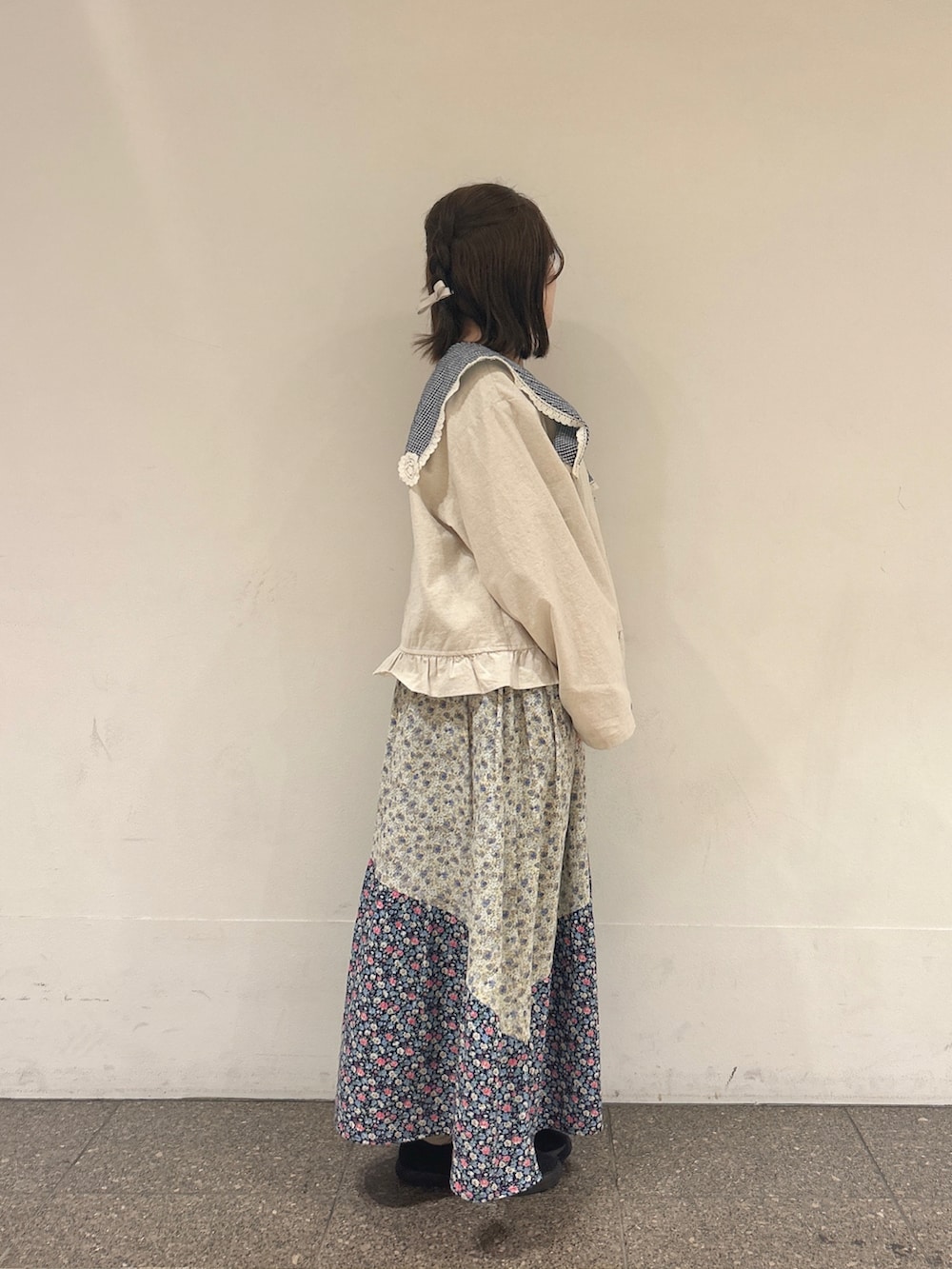 ホワイト系のノーカラージャケット、ブルー系のスカートを着用したレディースの春コーディネートの2枚目の写真