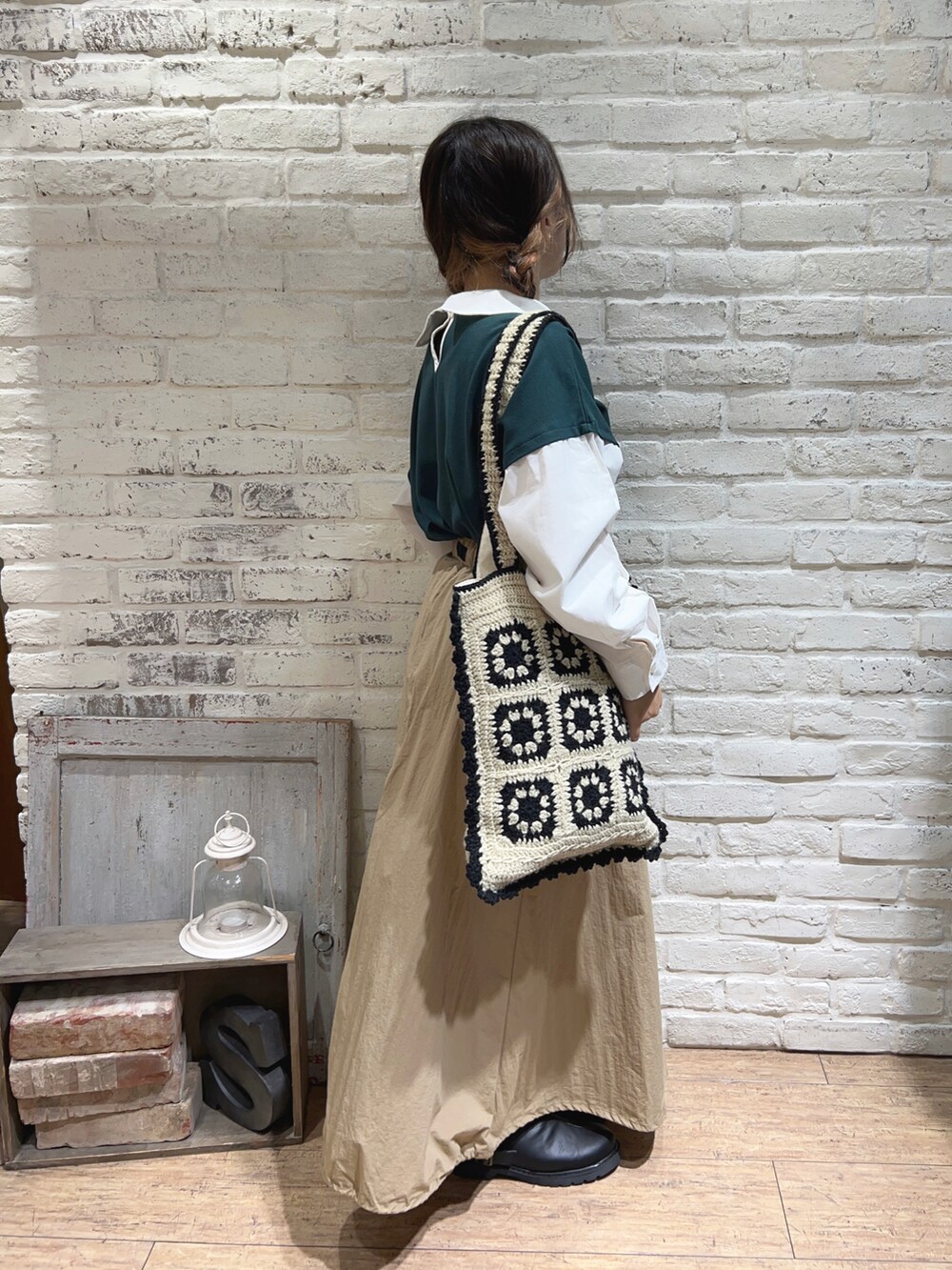 ベージュ系のハンドバッグ、ベージュ系のスカート、グリーン系のTシャツ/カットソーを着用したレディースの秋コーディネートの2枚目の写真