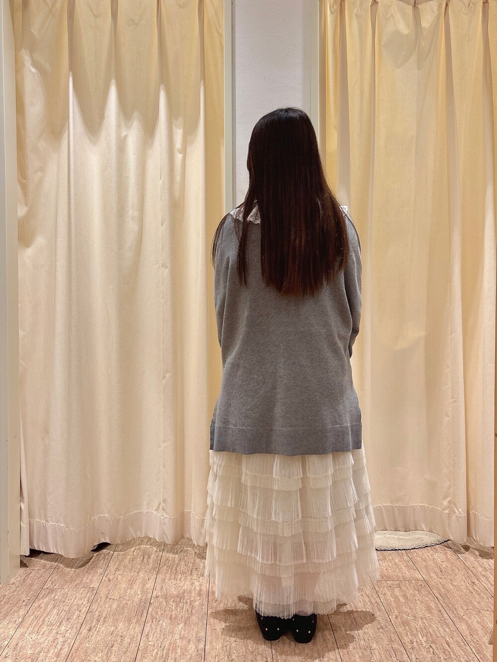 ホワイト系のスカート、ホワイト系のシャツ/ブラウス、グレー系のニット/セーターを着用したレディースの秋コーディネートの3枚目の写真