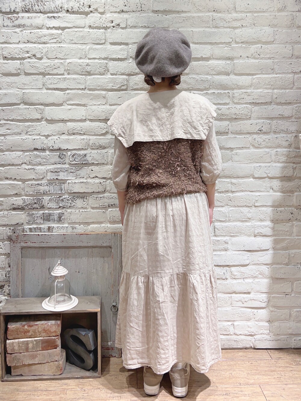 ベージュ系のワンピース、ブラウン系のベスト、ブラウン系のハットを着用したレディースの夏コーディネートの3枚目の写真