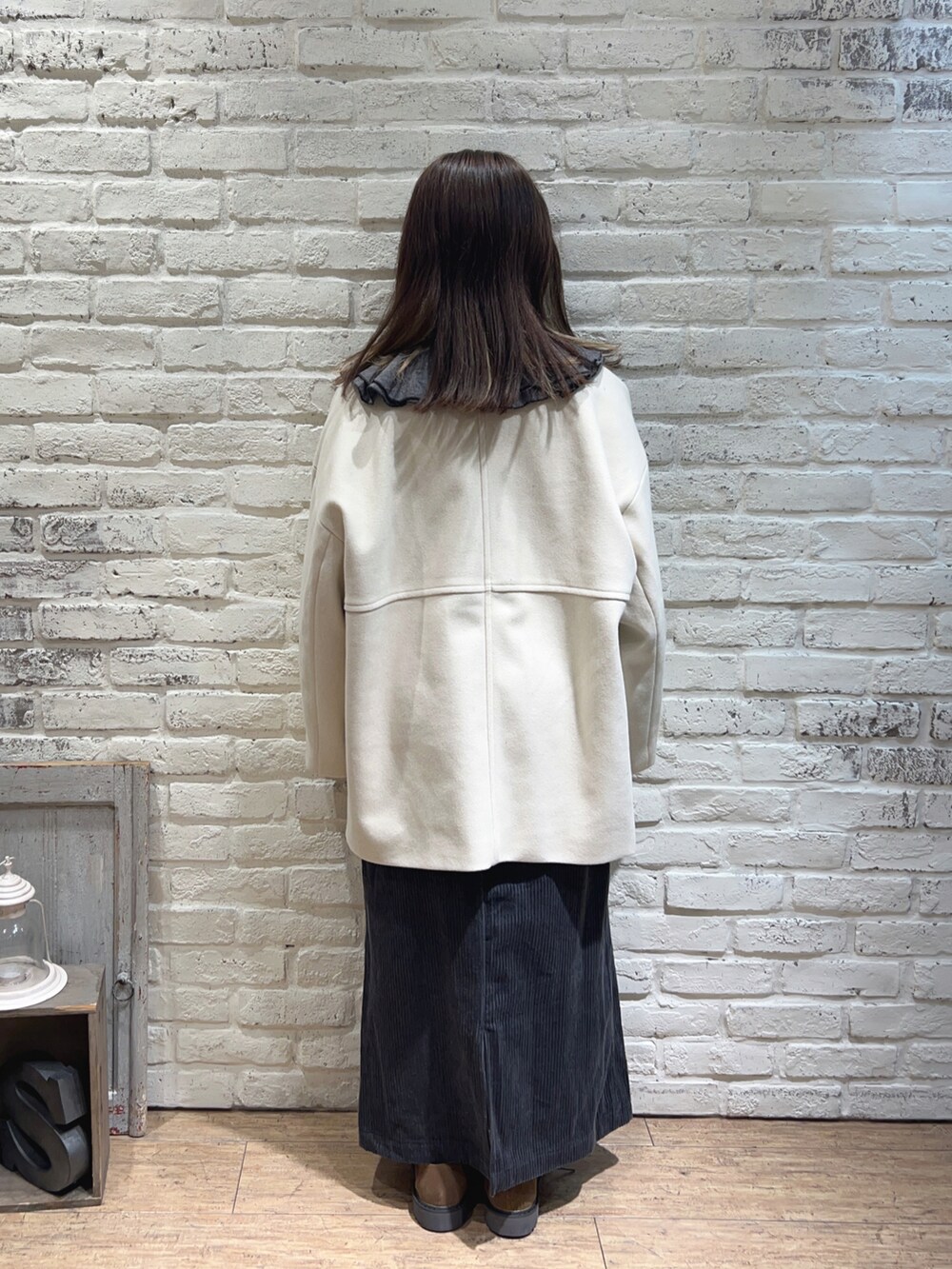 グレー系のシャツ/ブラウス、ホワイト系のその他アウター、ブルー系のスカートを着用したレディースの冬コーディネートの3枚目の写真