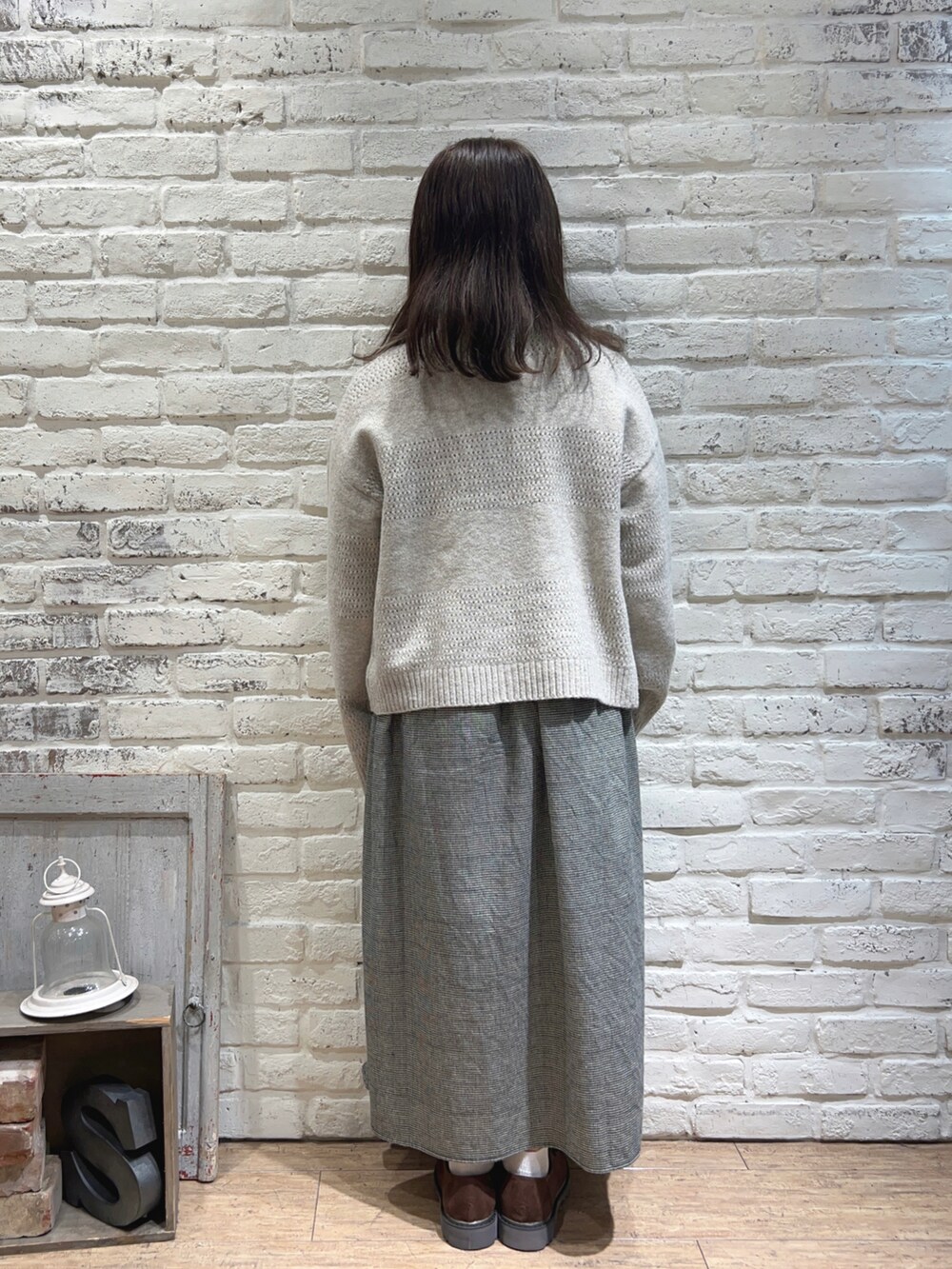 ホワイト系のワンピース、ベージュ系のカーディガン/ボレロ、ブラウン系のドレスシューズを着用したレディースの秋コーディネートの3枚目の写真