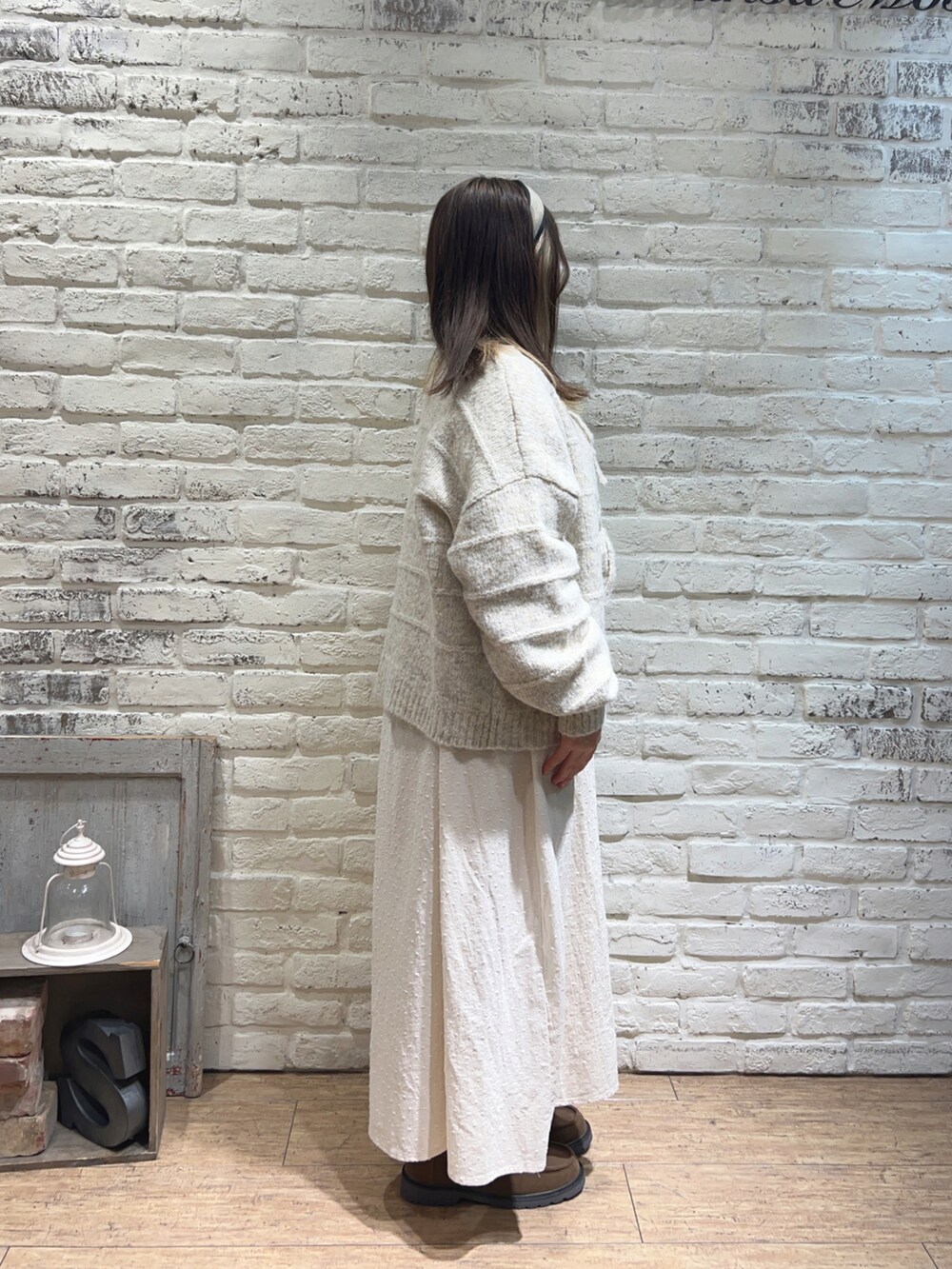 ホワイト系のカーディガン/ボレロ、ホワイト系のワンピース、ベージュ系のドレスシューズを着用したレディースの冬コーディネートの2枚目の写真