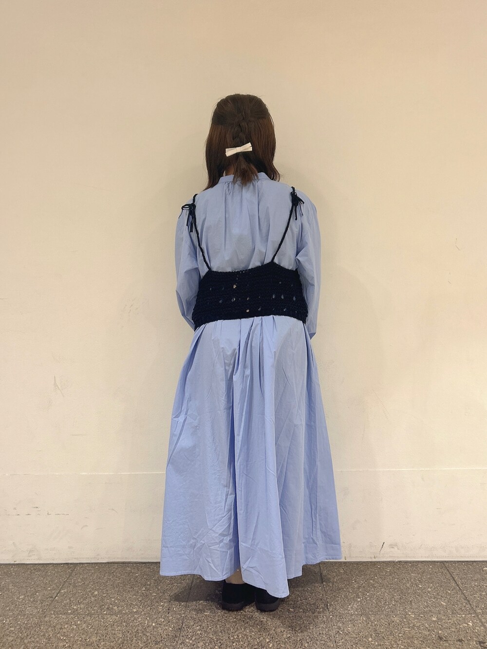 ブラック系のベスト、ブルー系のワンピースを着用したレディースの春コーディネートの3枚目の写真