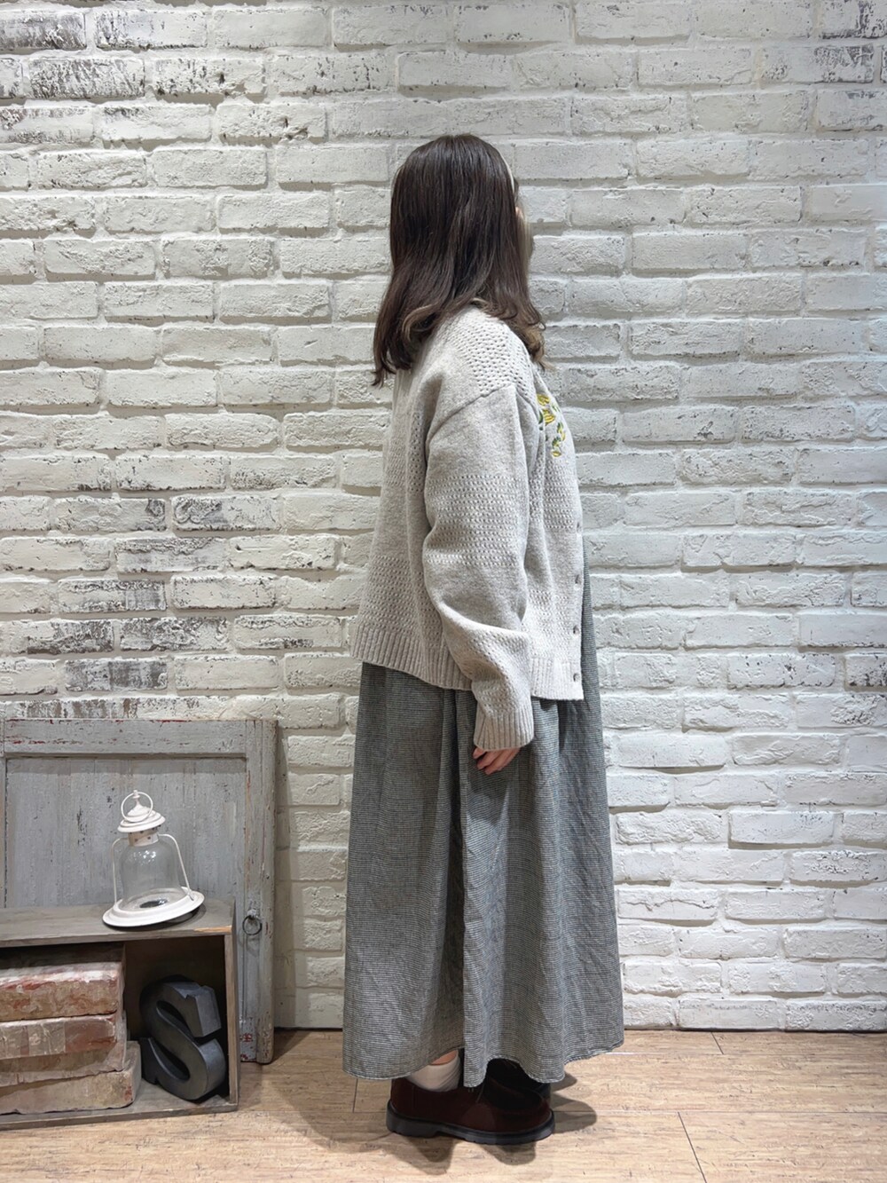 ホワイト系のワンピース、ベージュ系のカーディガン/ボレロ、ブラウン系のドレスシューズを着用したレディースの秋コーディネートの2枚目の写真