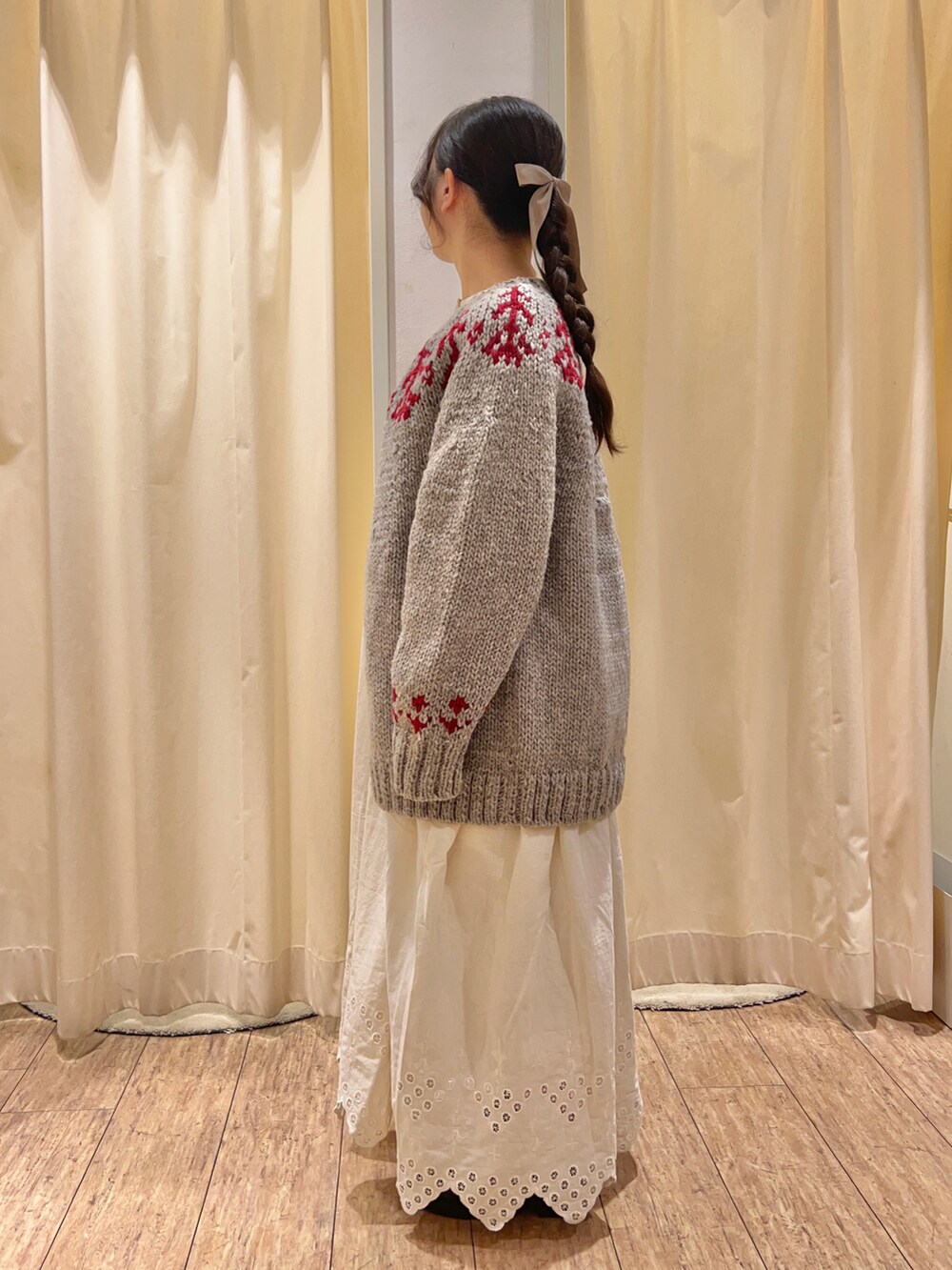 ホワイト系のワンピース、グレー系のカーディガン/ボレロを着用したレディースの秋コーディネートの2枚目の写真