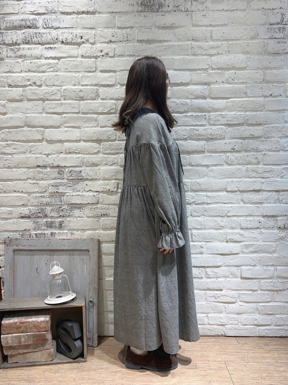 ホワイト系のワンピース、ブラウン系のドレスシューズ、ベージュ系のネックレスを着用したレディースの秋コーディネートの2枚目の写真