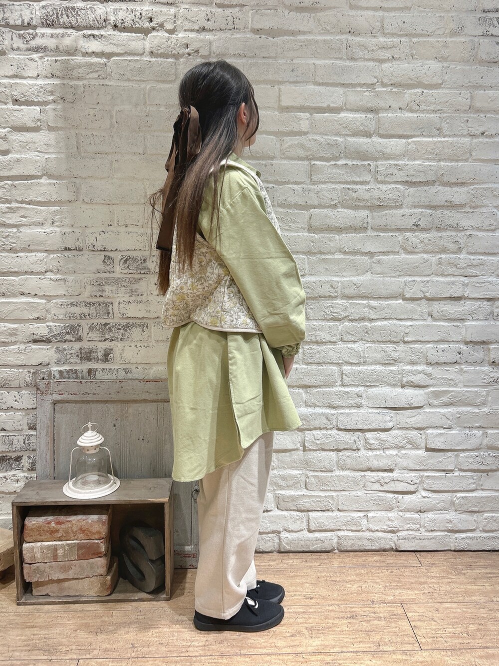 ホワイト系のベスト、グリーン系のチュニック、ベージュ系のその他パンツを着用したレディースの冬コーディネートの2枚目の写真